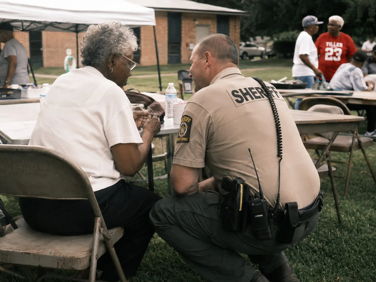 A sheriff's deputy speaking with a resident at a community event