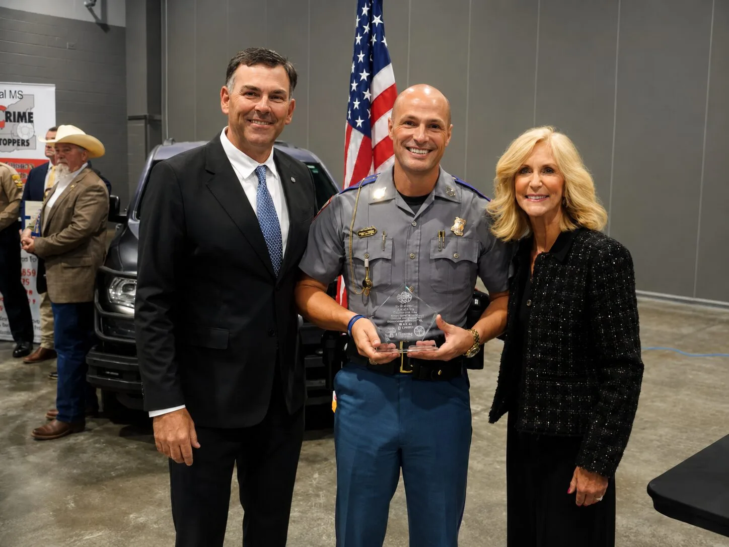 An officer holding an award at the MSCPS recognition event